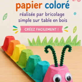 Chenille colorée en papier fabriquée à la main par des enfants, sur une table en bois.